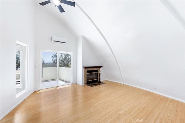 22870 Trigger St, Chatsworth, CA 91311 - unfurnished living room featuring an AC wall unit, a fireplace with flush hearth, light wood-style flooring, vaulted ceiling, and a ceiling fan