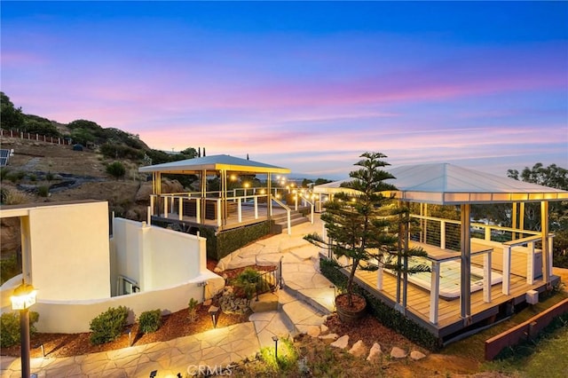 22870 Trigger St, Chatsworth, CA 91311 - back of house at dusk with a gazebo, stucco siding, and a deck