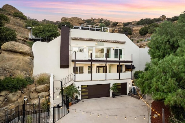 22870 Trigger St, Chatsworth, CA 91311 - view of front of house featuring a balcony, driveway, a garage, and stucco siding