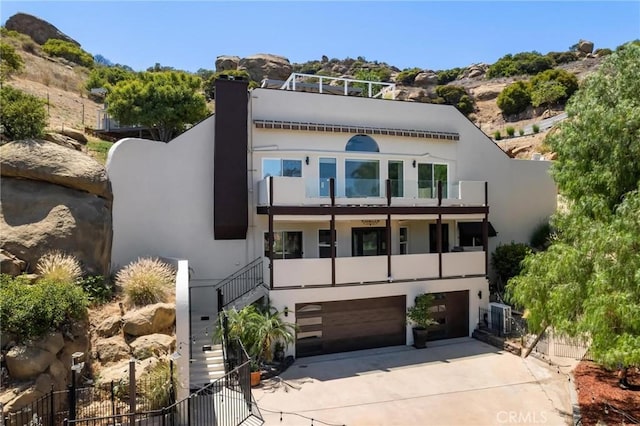 22870 Trigger St, Chatsworth, CA 91311 - view of front of house featuring a balcony, an attached garage, driveway, stucco siding, and a chimney