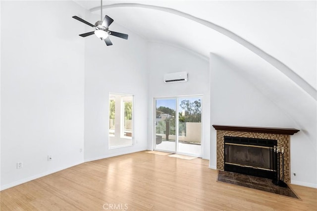 22870 Trigger St, Chatsworth, CA 91311 - unfurnished living room with a wall mounted AC, wood finished floors, ceiling fan, a fireplace, and high vaulted ceiling