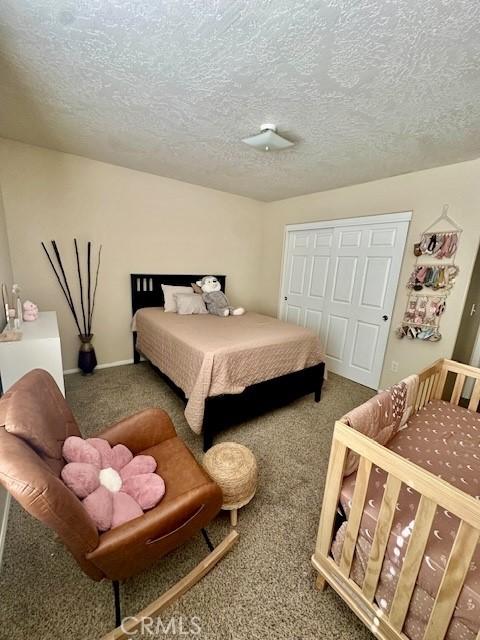13133 4th Ave, Victorville, CA 92395 - bedroom featuring carpet floors, a textured ceiling, and a closet