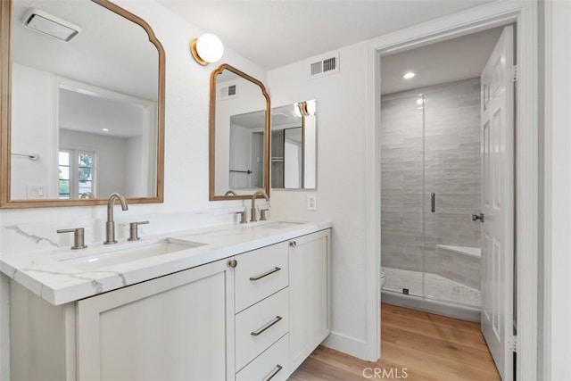 24616 Polaris Dr Unit 272, Dana Point, CA 92629 - bathroom featuring double vanity, wood finished floors, a stall shower, and recessed lighting