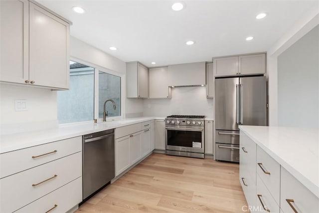 24616 Polaris Dr Unit 272, Dana Point, CA 92629 - kitchen featuring high quality appliances, light wood finished floors, recessed lighting, premium range hood, and gray cabinets