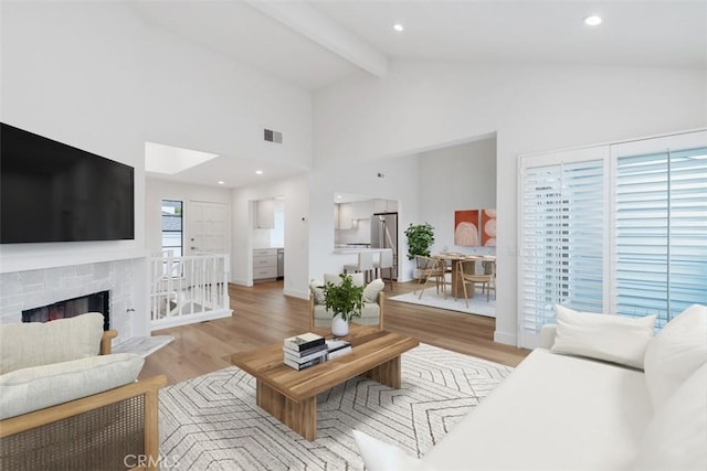 24616 Polaris Dr Unit 272, Dana Point, CA 92629 - living area with light wood-type flooring, beam ceiling, high vaulted ceiling, and a fireplace