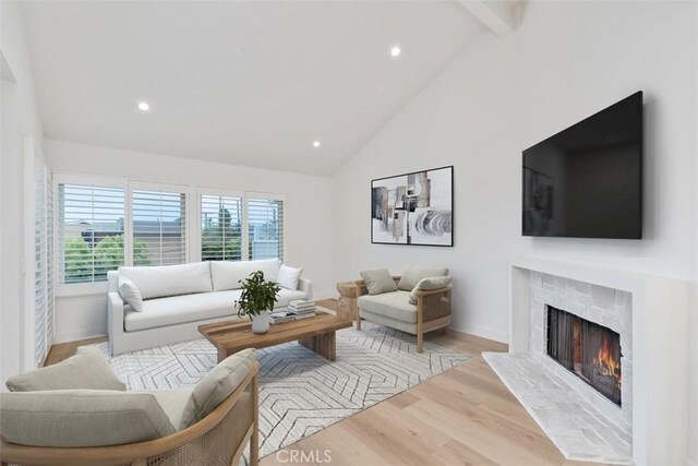 24616 Polaris Dr Unit 272, Dana Point, CA 92629 - living area with a warm lit fireplace, wood finished floors, recessed lighting, beam ceiling, and high vaulted ceiling