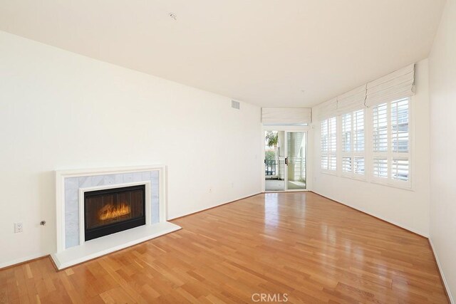 2600 Newport Blvd Unit 219, Newport Beach, CA 92663 - unfurnished living room featuring wood finished floors and a glass covered fireplace