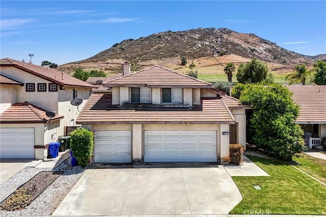 16737 Windcrest Dr, Fontana, CA 92337 - view of front facade with stucco siding, concrete driveway, a mountain view, and a tile roof