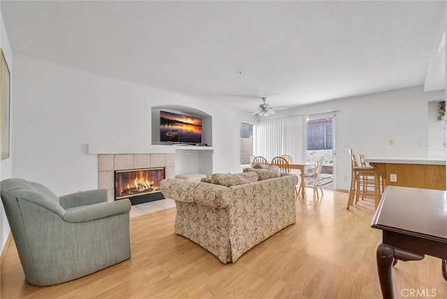 16737 Windcrest Dr, Fontana, CA 92337 - living room featuring light wood-style floors, ceiling fan, and a tile fireplace