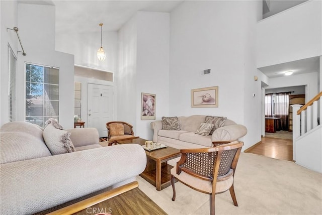 16737 Windcrest Dr, Fontana, CA 92337 - living room with a high ceiling, stairway, and light carpet