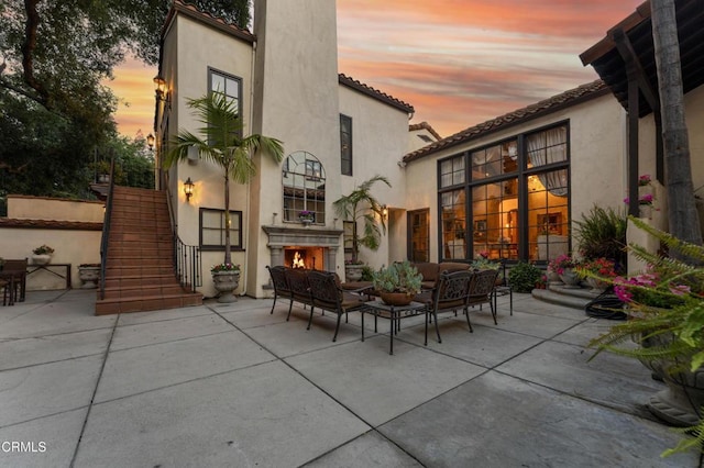 1205 Linda Vista Ave, Pasadena, CA 91103 - back of house at dusk with a patio area, stairs, and an outdoor living space with a fireplace