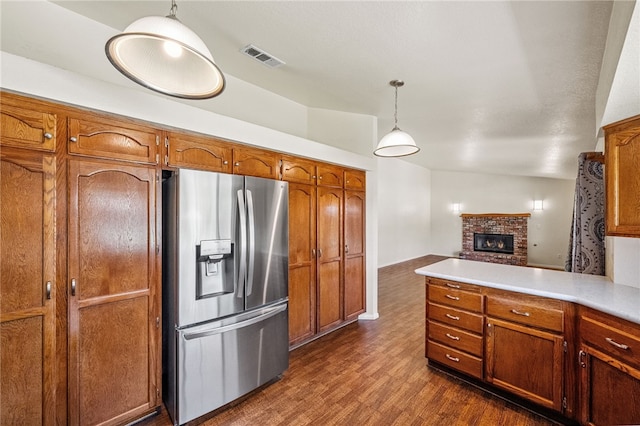 32618 Durango Ct, Wildomar, CA 92595 - kitchen with stainless steel refrigerator with ice dispenser, brown cabinets, a brick fireplace, and dark wood finished floors