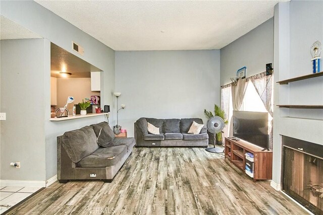 11131 Dodson St Unit 7, El Monte, CA 91733 - living room with wood finished floors, a fireplace, and a textured ceiling