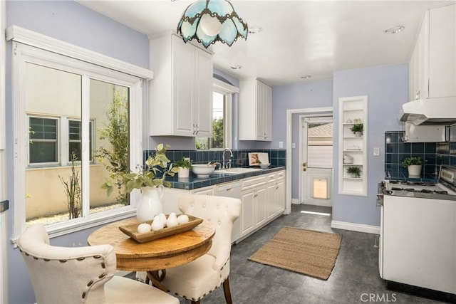 2412 Santiago St, Santa Ana, CA 92706 - kitchen with white gas range oven, under cabinet range hood, white cabinetry, tasteful backsplash, and tile countertops