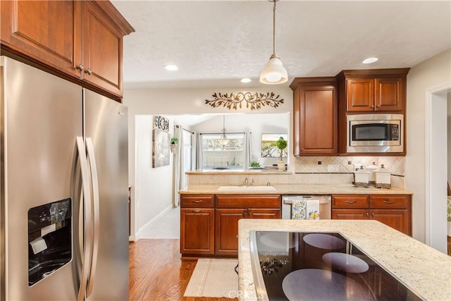 3191 Woodstock Rd, Rossmoor, CA 90720 - kitchen featuring appliances with stainless steel finishes, brown cabinets, decorative light fixtures, decorative backsplash, and recessed lighting