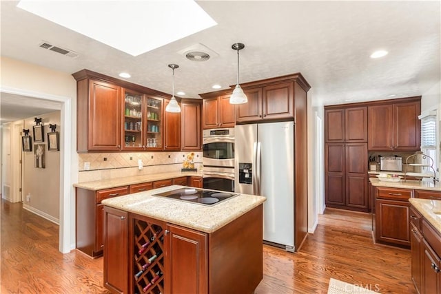 3191 Woodstock Rd, Rossmoor, CA 90720 - kitchen with stainless steel appliances, dark wood finished floors, tasteful backsplash, pendant lighting, and recessed lighting