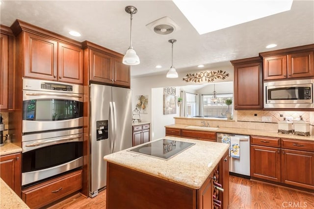 3191 Woodstock Rd, Rossmoor, CA 90720 - kitchen featuring appliances with stainless steel finishes, tasteful backsplash, wood finished floors, a kitchen island, and recessed lighting