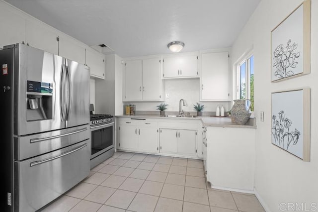 4454 Ute Dr, San Diego, CA 92117 - kitchen featuring appliances with stainless steel finishes, light countertops, light tile patterned floors, and white cabinetry
