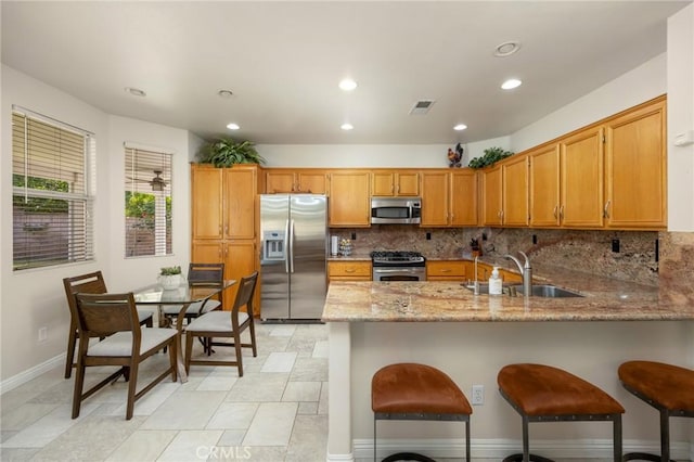 1581 Manor Ln, Glendora, CA 91741 - kitchen with stainless steel appliances, a peninsula, backsplash, light stone counters, and recessed lighting