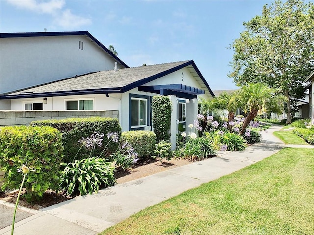 16573 Pescado Ln Unit 3A, Huntington Beach, CA 92649 - view of front facade featuring a shingled roof, stucco siding, and a front yard