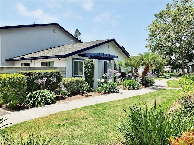 16573 Pescado Ln Unit 3A, Huntington Beach, CA 92649 - view of front facade featuring a front lawn, a pergola, stucco siding, and a shingled roof