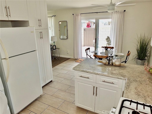 16573 Pescado Ln Unit 3A, Huntington Beach, CA 92649 - kitchen with freestanding refrigerator, white cabinets, light countertops, light tile patterned floors, and ceiling fan