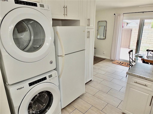 16573 Pescado Ln Unit 3A, Huntington Beach, CA 92649 - laundry area featuring stacked washing machine and dryer and light tile patterned floors
