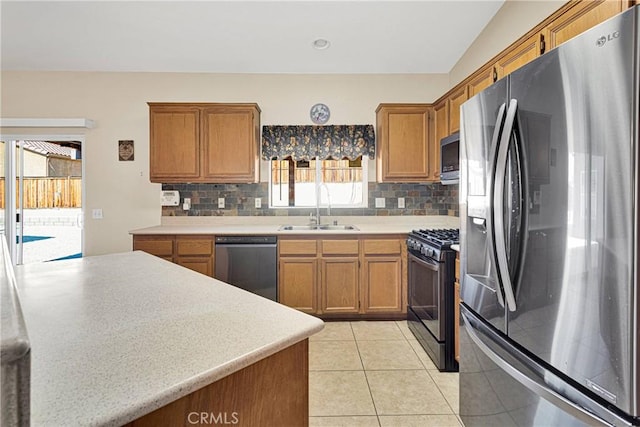 16029 Carmelia Dr, Victorville, CA 92394 - kitchen with stainless steel appliances, backsplash, brown cabinets, and healthy amount of natural light