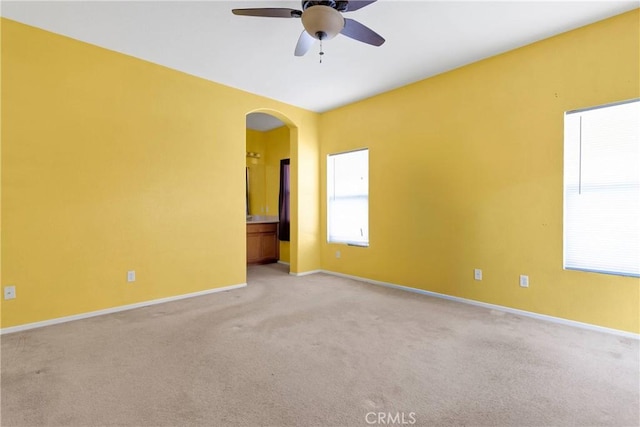 16029 Carmelia Dr, Victorville, CA 92394 - unfurnished room featuring light carpet, arched walkways, and a ceiling fan