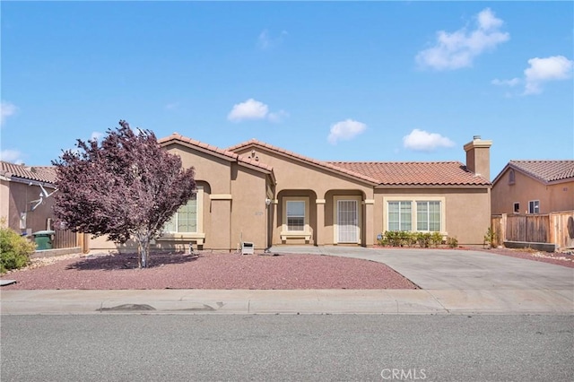 16029 Carmelia Dr, Victorville, CA 92394 - mediterranean / spanish house with stucco siding, a tile roof, concrete driveway, and a chimney