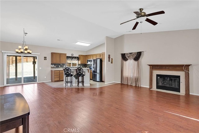 16029 Carmelia Dr, Victorville, CA 92394 - living area featuring a chandelier, vaulted ceiling, a high end fireplace, light wood-style flooring, and ceiling fan
