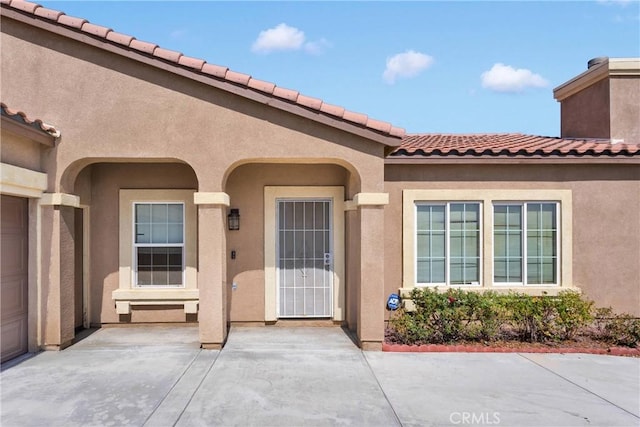 16029 Carmelia Dr, Victorville, CA 92394 - property entrance featuring a tiled roof, stucco siding, and a patio area