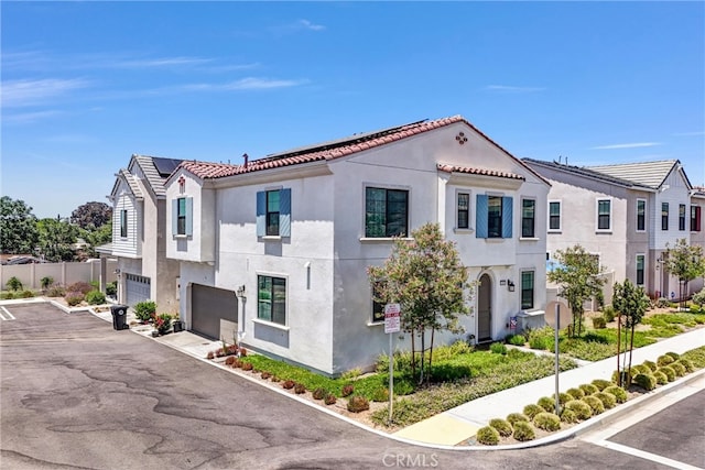 34410 Granite Rd, Yucaipa, CA 92399 - view of front of property featuring stucco siding, an attached garage, a tile roof, and roof mounted solar panels