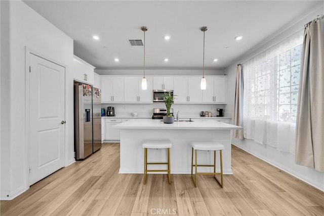 34410 Granite Rd, Yucaipa, CA 92399 - kitchen with appliances with stainless steel finishes, light countertops, light wood-style floors, white cabinetry, and recessed lighting