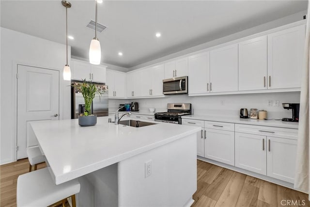 34410 Granite Rd, Yucaipa, CA 92399 - kitchen with appliances with stainless steel finishes, white cabinetry, light wood-style floors, and recessed lighting