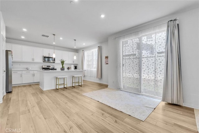 34410 Granite Rd, Yucaipa, CA 92399 - kitchen with appliances with stainless steel finishes, white cabinets, light wood-type flooring, recessed lighting, and light countertops
