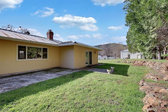 13001 Yuba Nevada Rd, Dobbins, CA 95935 - back of property featuring french doors, a chimney, a yard, a metal roof, and a patio