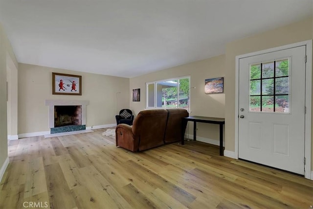 13001 Yuba Nevada Rd, Dobbins, CA 95935 - living area featuring light wood-type flooring, plenty of natural light, and a fireplace with raised hearth