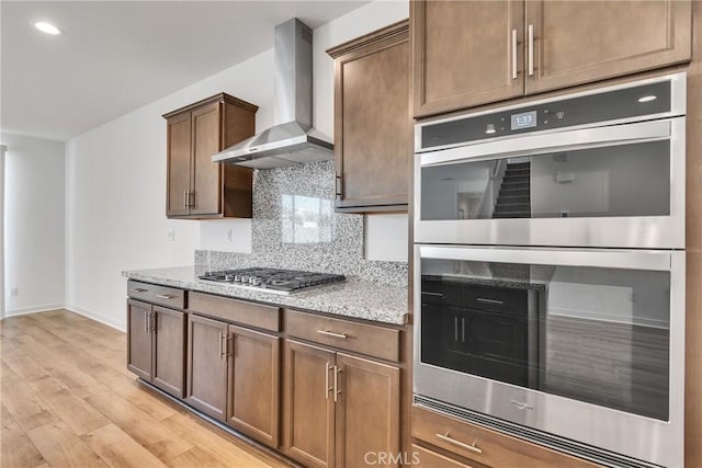 29812 Juniper Ct, Menifee, CA 92584 - kitchen featuring stainless steel appliances, wall chimney range hood, tasteful backsplash, light wood finished floors, and light stone countertops