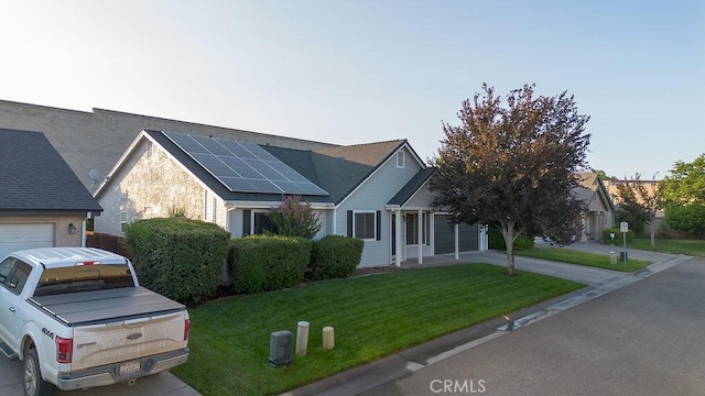 1085 Admiral Ln, Chico, CA 95973 - view of front facade featuring solar panels, a front lawn, driveway, and a garage