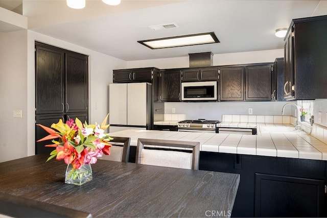 1085 Admiral Ln, Chico, CA 95973 - kitchen featuring white appliances, tile counters, and a peninsula