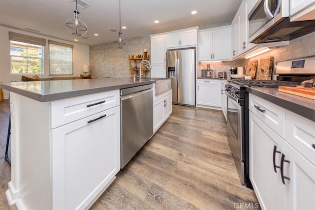 28606 Jardineras Dr, Valencia, CA 91354 - kitchen featuring appliances with stainless steel finishes, dark countertops, recessed lighting, light wood-type flooring, and white cabinetry