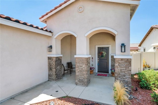 7002 Alice St, Highland, CA 92346 - view of exterior entry with stucco siding, stone siding, and a tiled roof