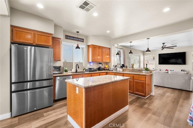 3094 Crooked Branch Way, San Jacinto, CA 92582 - kitchen with stainless steel appliances, a peninsula, a center island, open floor plan, and light wood finished floors