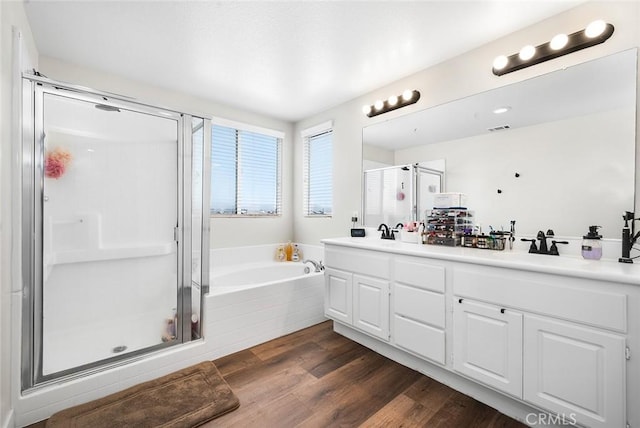 3094 Crooked Branch Way, San Jacinto, CA 92582 - bathroom featuring a stall shower, a garden tub, double vanity, and wood finished floors