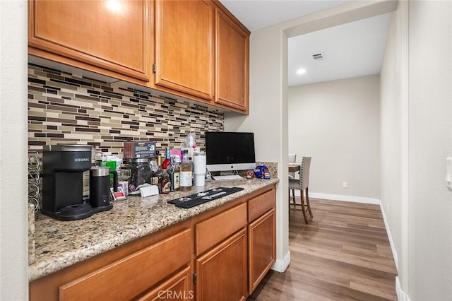 3094 Crooked Branch Way, San Jacinto, CA 92582 - kitchen featuring tasteful backsplash, light wood-style flooring, brown cabinets, light stone countertops, and recessed lighting