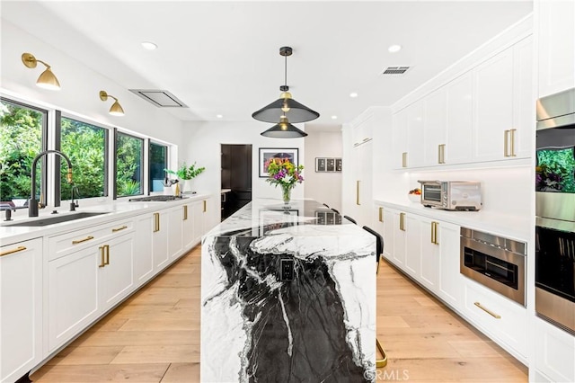 19258 Berclair Ln, Tarzana, CA 91356 - kitchen with stainless steel appliances, white cabinets, recessed lighting, a center island, and hanging light fixtures