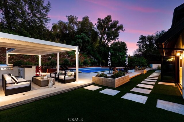 19258 Berclair Ln, Tarzana, CA 91356 - pool at dusk featuring exterior kitchen, an outdoor living space, a patio, an outdoor pool, and a lawn