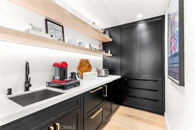 19258 Berclair Ln, Tarzana, CA 91356 - kitchen featuring open shelves, light wood finished floors, light countertops, and dark cabinetry