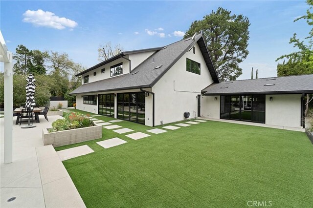 19258 Berclair Ln, Tarzana, CA 91356 - rear view of house with stucco siding, a patio, a yard, and a shingled roof
